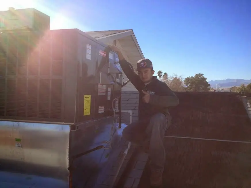 HVAC technician performing Heat Pump Repair on a rooftop unit in Borger